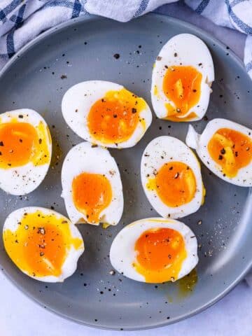 Four boiled eggs, all cut in half, with the yolks oozing out.