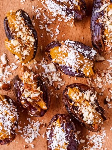 Peanut butter stuffed dates on a wooden serving board.