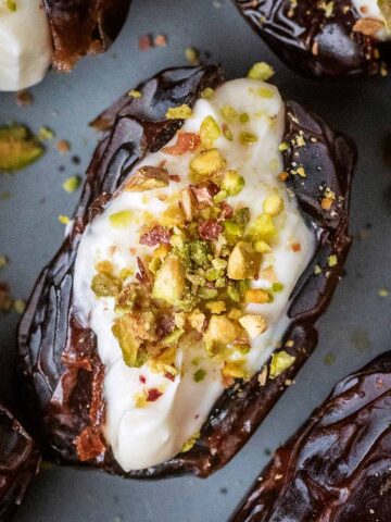 A cream cheese stuffed date on a grey plate.
